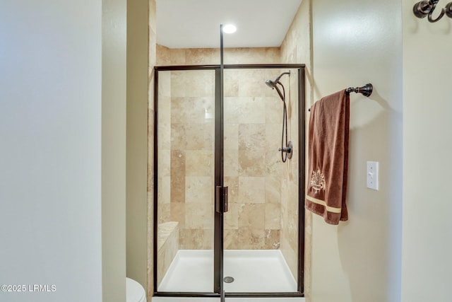 bathroom with toilet and an enclosed shower