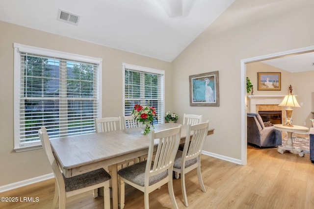 dining area with vaulted ceiling and light wood-type flooring