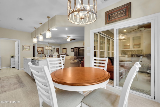 dining space featuring visible vents, baseboards, and ceiling fan with notable chandelier