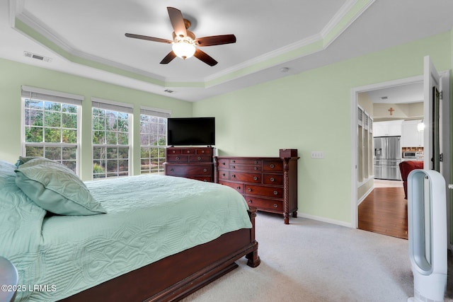 carpeted bedroom with stainless steel fridge with ice dispenser, a raised ceiling, visible vents, ornamental molding, and baseboards