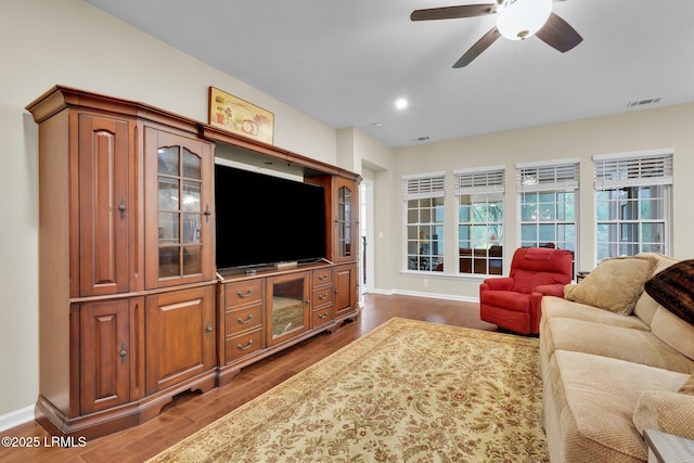 living area with baseboards, visible vents, and dark wood-style flooring