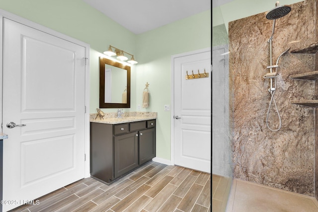 full bathroom featuring wood tiled floor, vanity, and a walk in shower