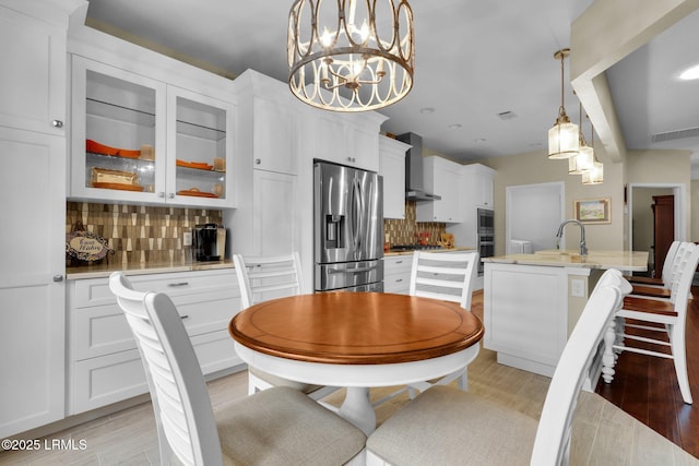 dining space with light wood-style floors and visible vents