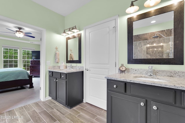 ensuite bathroom featuring two vanities, a walk in shower, a sink, and ensuite bathroom