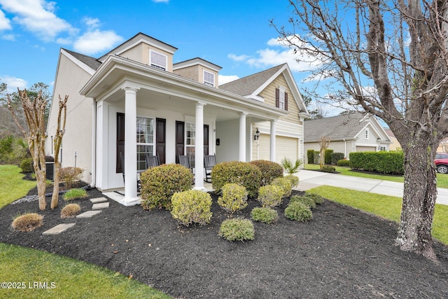 neoclassical home featuring a garage, driveway, and a porch