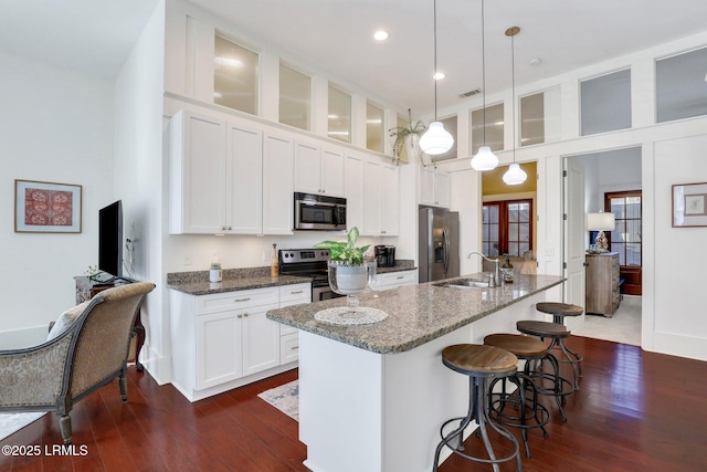 10 Abbey Row Unit 1A, Beaufort, SC 29906 - kitchen with visible vents, dark wood finished floors, a towering ceiling, stainless steel appliances, and a sink