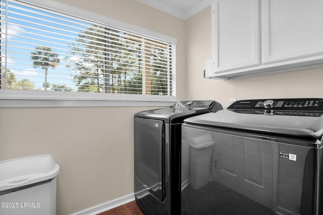 laundry room with cabinets, washing machine and dryer, crown molding, and dark wood-type flooring