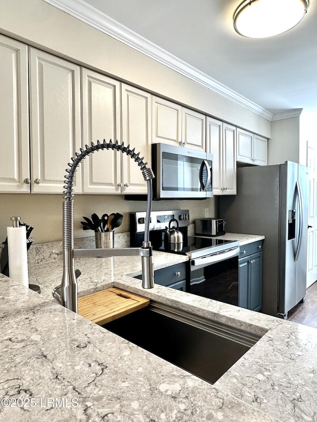 kitchen featuring hardwood / wood-style floors, crown molding, stainless steel appliances, and light stone countertops