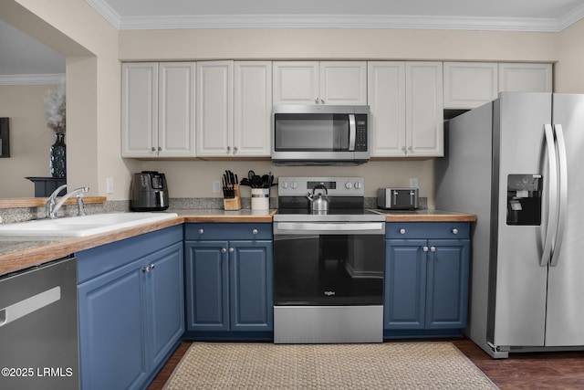 kitchen featuring blue cabinets, white cabinetry, sink, stainless steel appliances, and crown molding