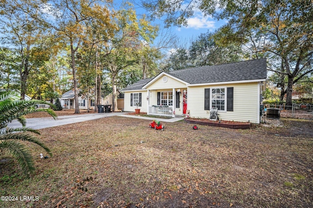 ranch-style house with a front lawn, central air condition unit, and a porch