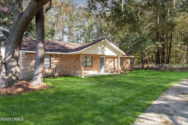 ranch-style home with brick siding, a front yard, and fence