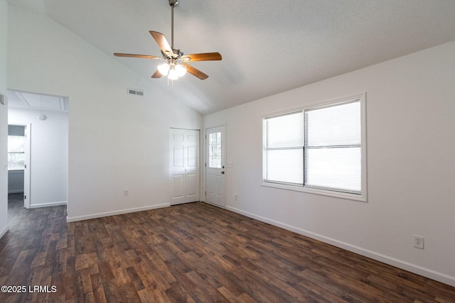 empty room featuring dark wood-style flooring, visible vents, attic access, a ceiling fan, and baseboards