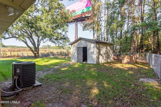 view of yard featuring an outbuilding, central AC, a storage unit, and a fenced backyard