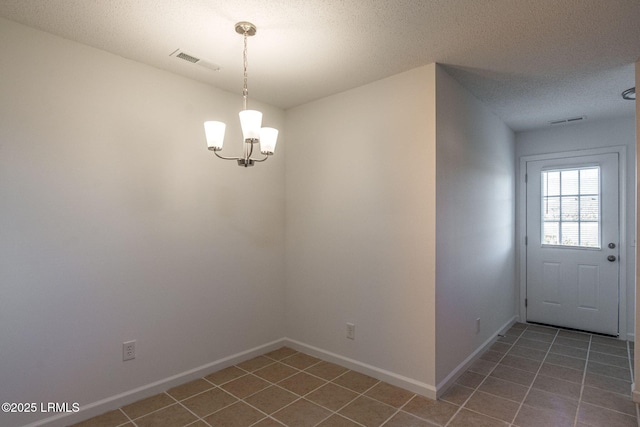 interior space with a chandelier, tile patterned floors, visible vents, and baseboards