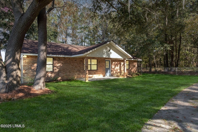 ranch-style house featuring brick siding, a front yard, and fence