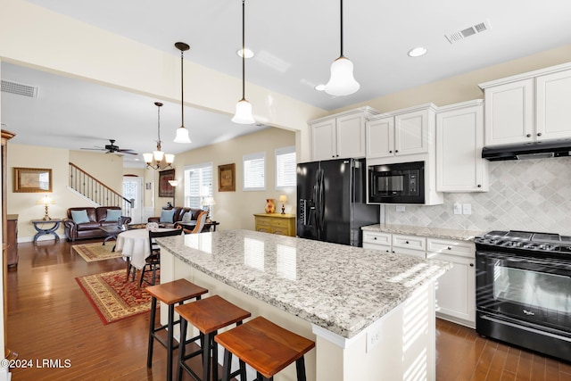 kitchen featuring white cabinetry, backsplash, and black appliances