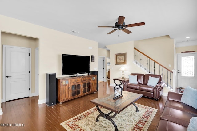 living room featuring dark wood-type flooring and ceiling fan