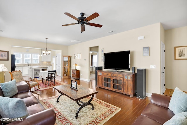 living room featuring sink, ceiling fan with notable chandelier, and dark hardwood / wood-style flooring