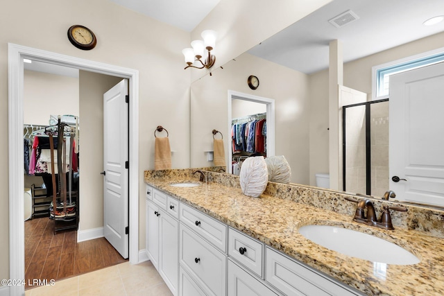 bathroom featuring tile patterned floors, vanity, toilet, and a shower with shower door