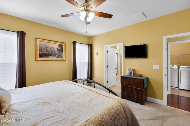 carpeted bedroom featuring separate washer and dryer, ensuite bath, and ceiling fan