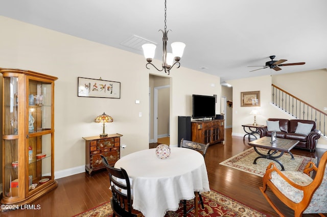 dining area with dark hardwood / wood-style flooring and ceiling fan with notable chandelier