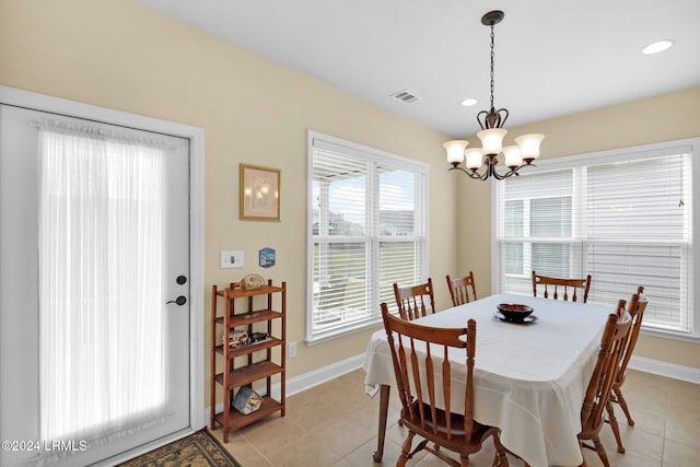 tiled dining room featuring an inviting chandelier