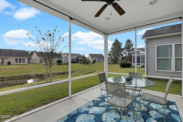 sunroom / solarium with a water view, plenty of natural light, and ceiling fan