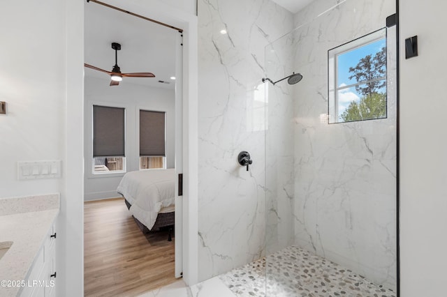 ensuite bathroom featuring a marble finish shower, a ceiling fan, vanity, and ensuite bath