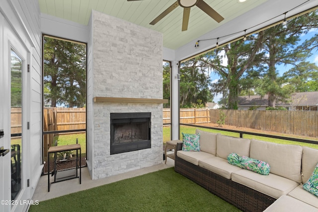 sunroom / solarium featuring an outdoor living space with a fireplace and a ceiling fan