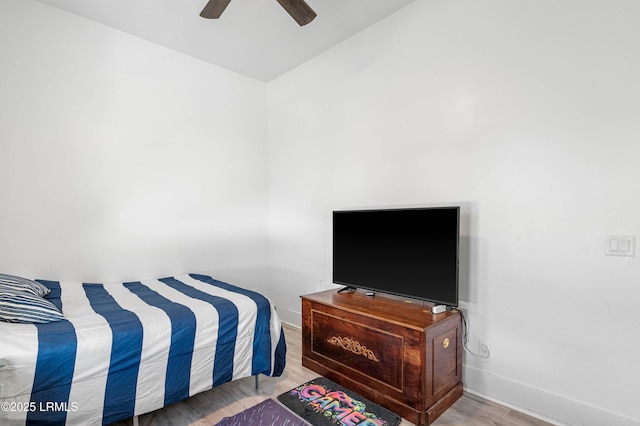 bedroom with a ceiling fan, vaulted ceiling, wood finished floors, and baseboards