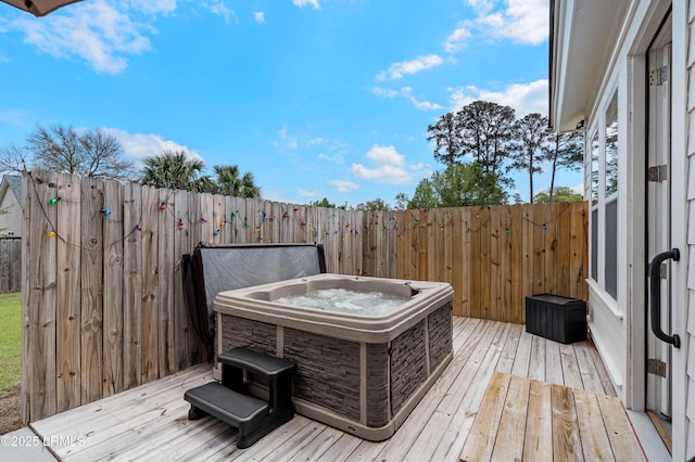 wooden terrace with fence and a hot tub