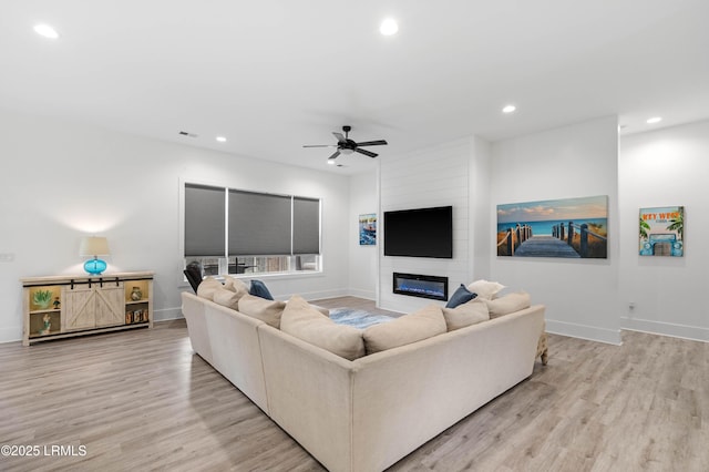 living area with recessed lighting, ceiling fan, and light wood-style floors