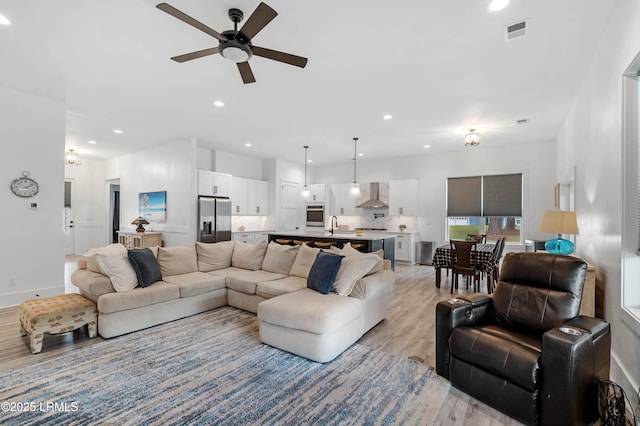 living room with recessed lighting, a ceiling fan, visible vents, and light wood-style floors