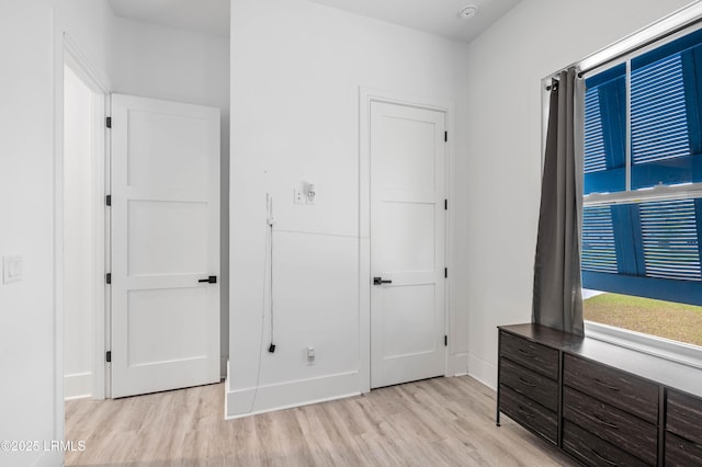 unfurnished bedroom featuring light wood-style flooring and baseboards