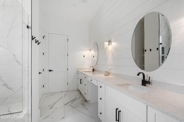 bathroom featuring marble finish floor, a sink, and double vanity