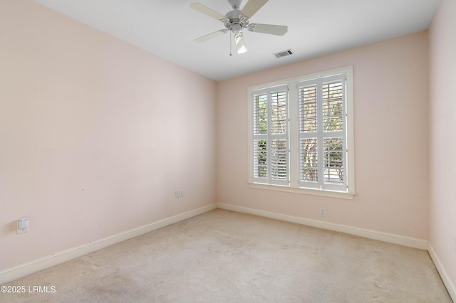 spare room featuring light carpet, visible vents, and baseboards