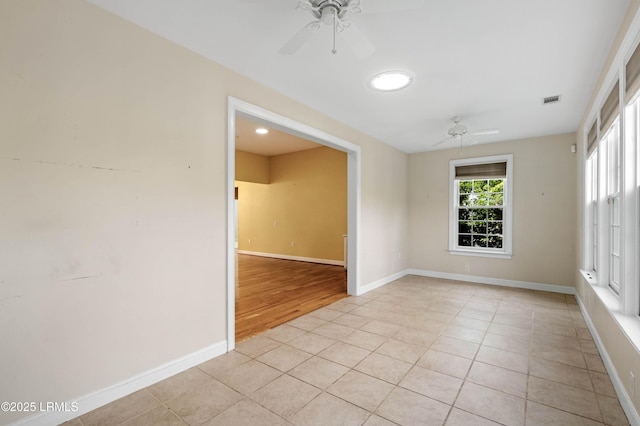 empty room featuring visible vents, baseboards, ceiling fan, and light tile patterned floors