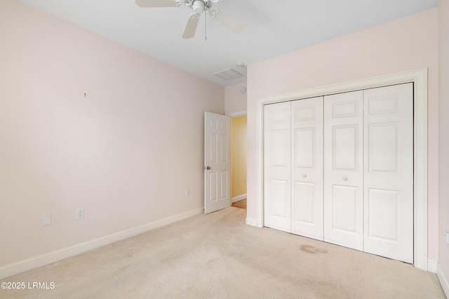 unfurnished bedroom with carpet, a closet, a ceiling fan, and baseboards