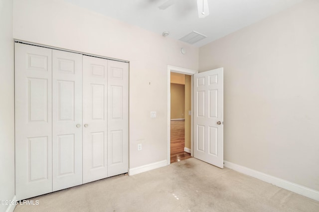 unfurnished bedroom with carpet, baseboards, a ceiling fan, and a closet