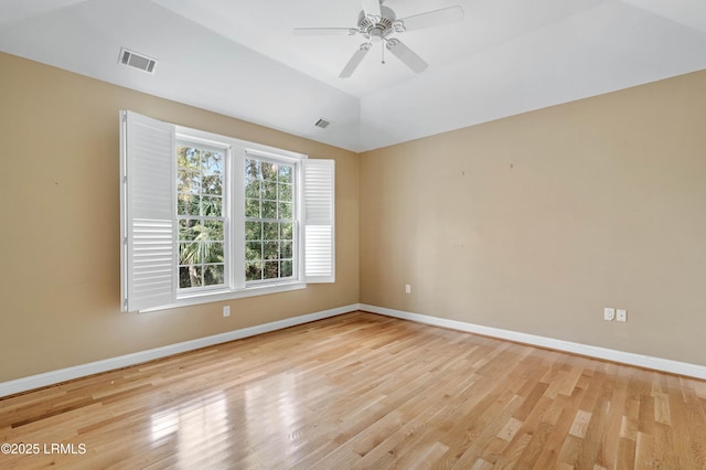 spare room featuring baseboards, a ceiling fan, light wood-style floors, and visible vents