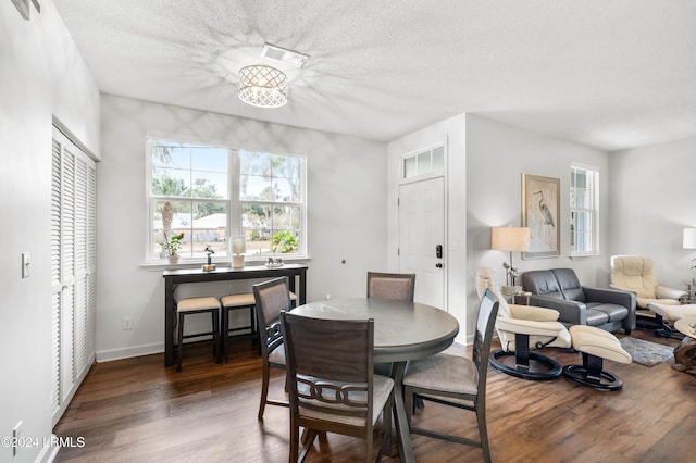 dining space featuring dark hardwood / wood-style flooring and a textured ceiling