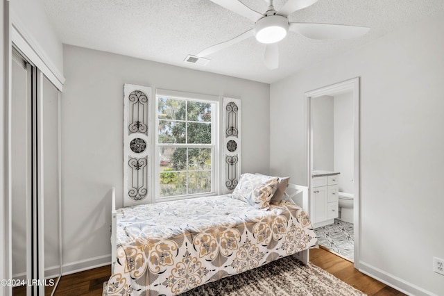 bedroom featuring dark wood-type flooring, a textured ceiling, ceiling fan, and a closet