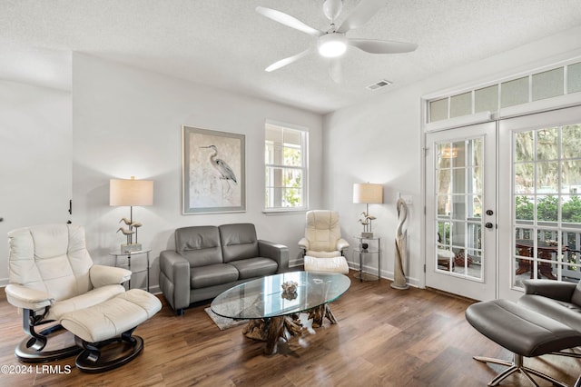 living room featuring hardwood / wood-style floors, french doors, a textured ceiling, and ceiling fan