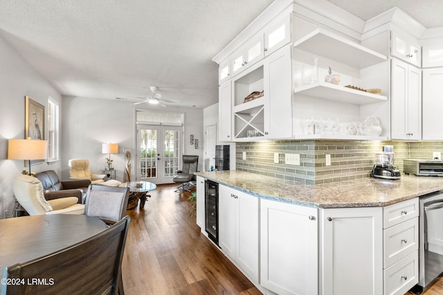 kitchen featuring white cabinetry, wine cooler, decorative backsplash, light stone counters, and dark wood-type flooring