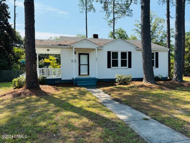 ranch-style home with a front lawn and a porch