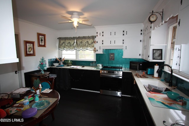 kitchen featuring sink, ornamental molding, white cabinets, decorative backsplash, and oven