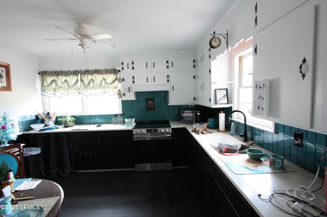 kitchen with white cabinetry, sink, backsplash, ceiling fan, and electric stove