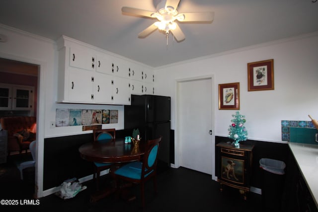 kitchen with crown molding, black fridge, and white cabinets