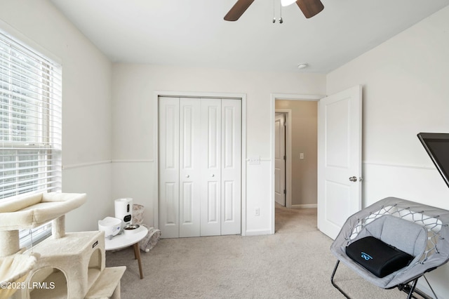 living area with light colored carpet and ceiling fan