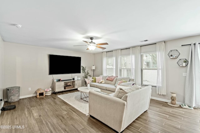 living room with light hardwood / wood-style floors and ceiling fan